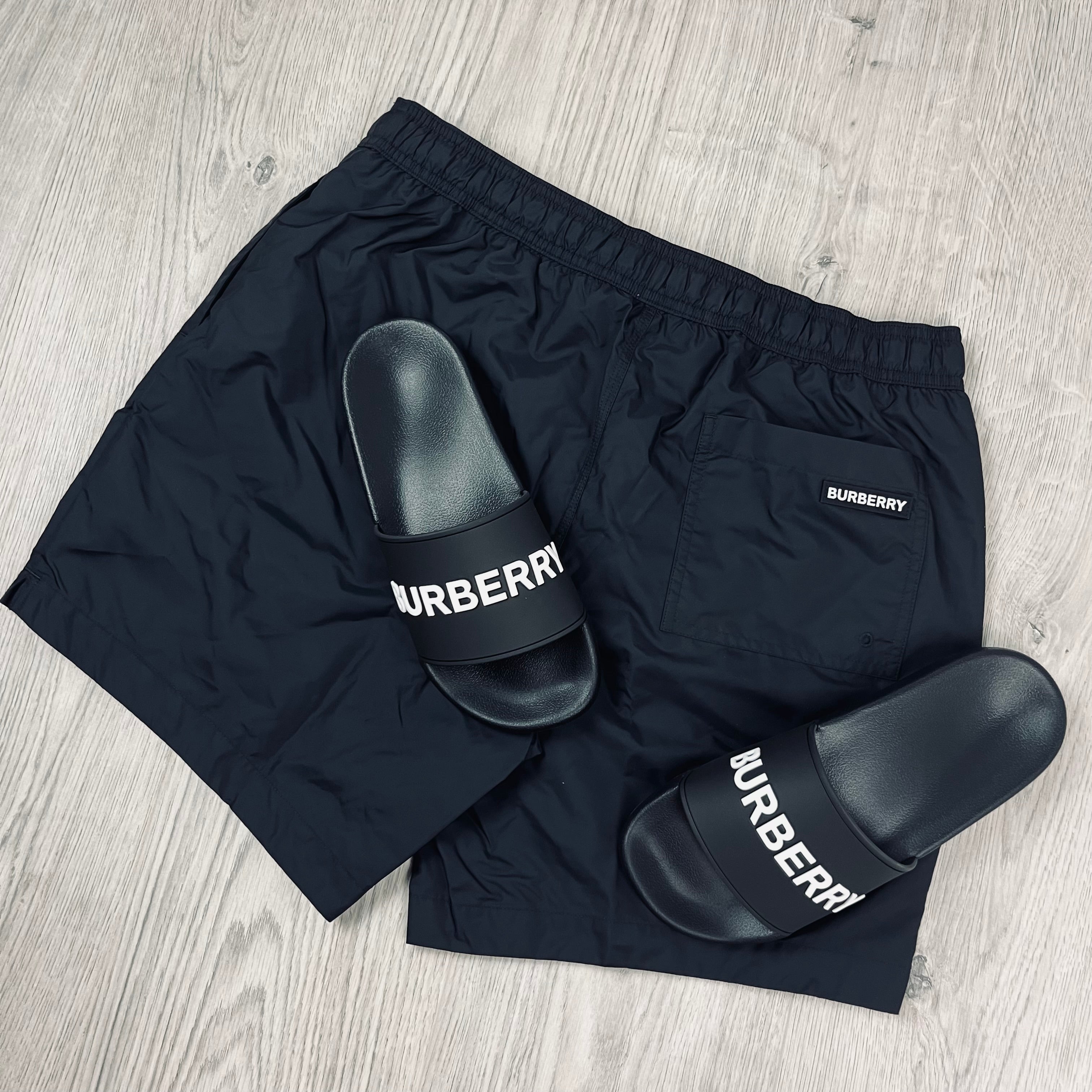 Burberry Holiday Set consisting of slides and swim shorts in Black. On sale at Open Attire.