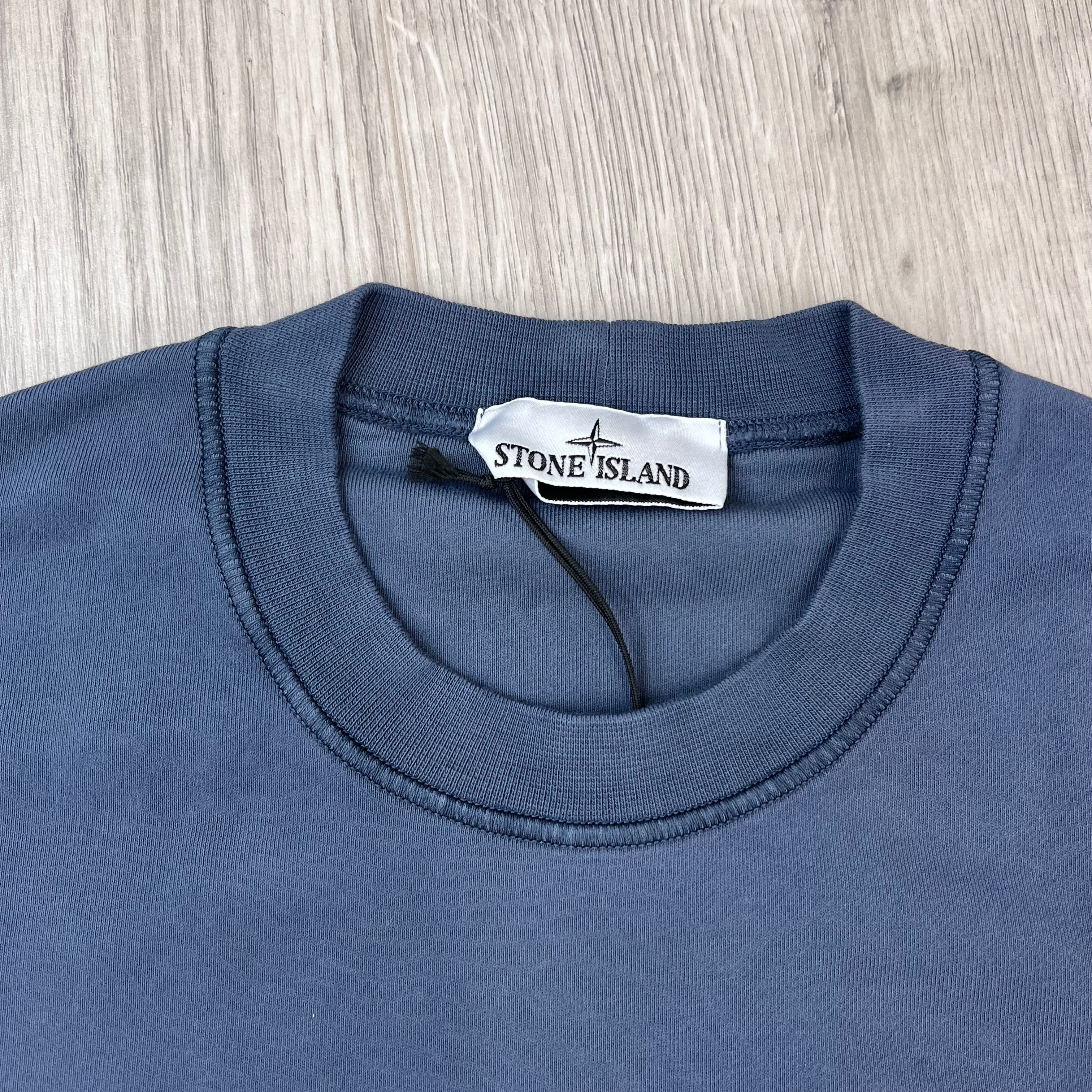 A close up view of the crewneck and label on a Stone Island Crewneck Sweatshirt in Slate Blue.
