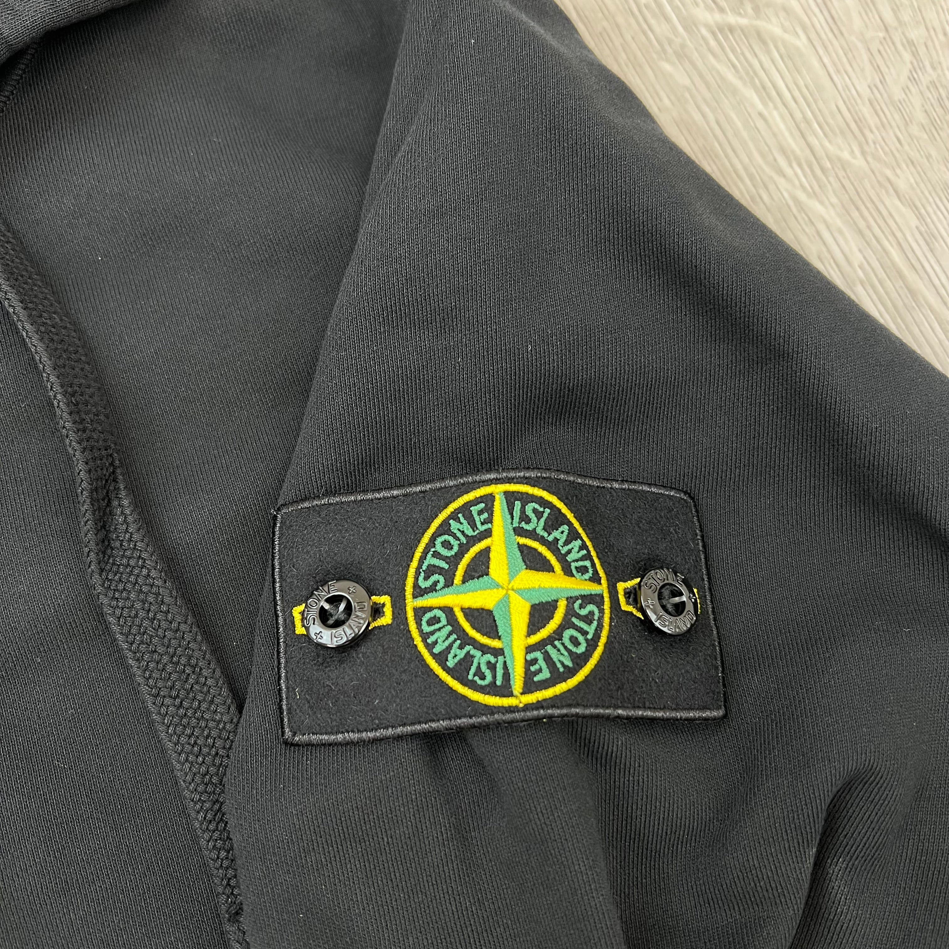 A close up view of the badge logo on the Stone Island Zip Hoodie in Black.