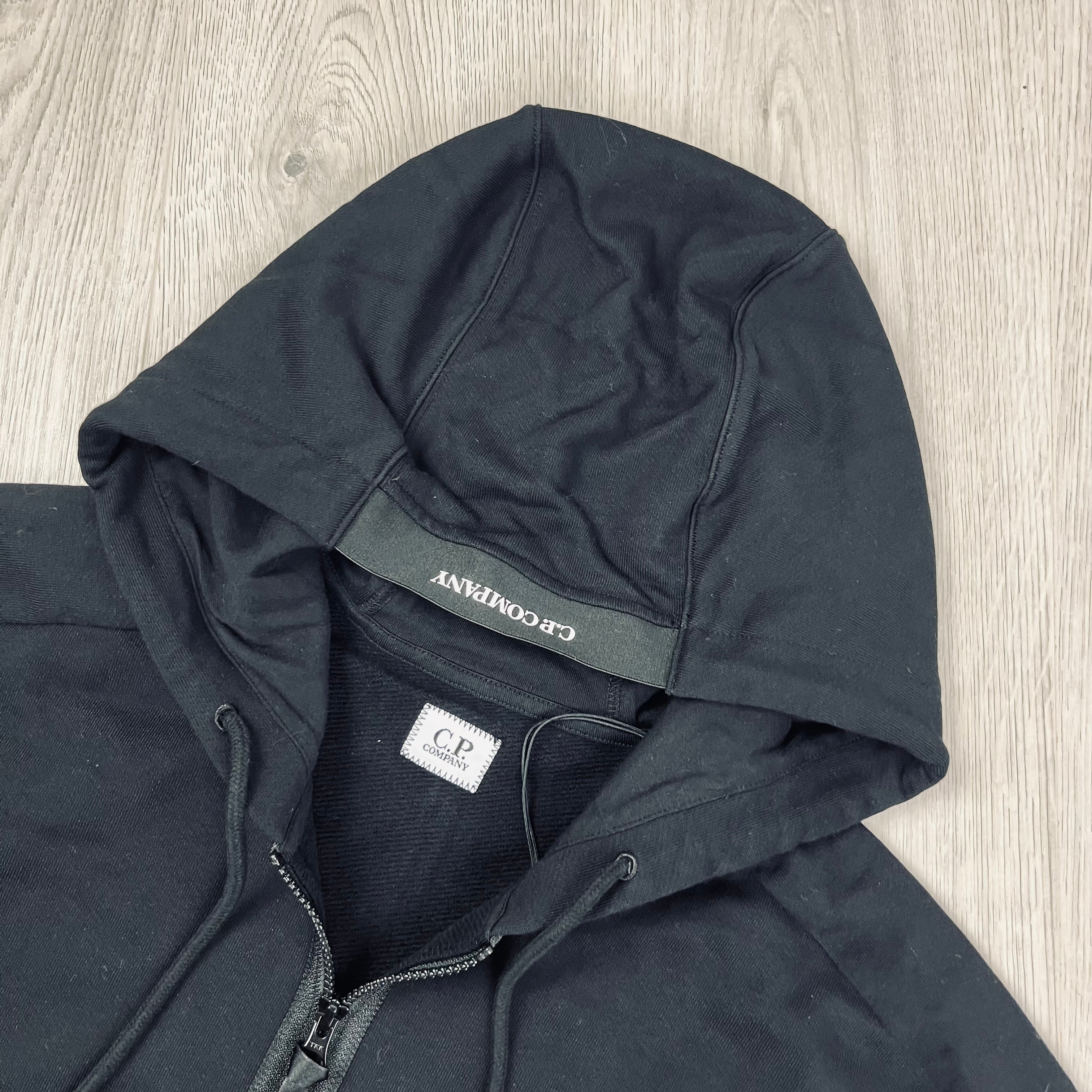 CP Company Diagonal Raised Fleece Zipped Hoodie with sleeve lens detail in Black. On Sale at Open Attire.