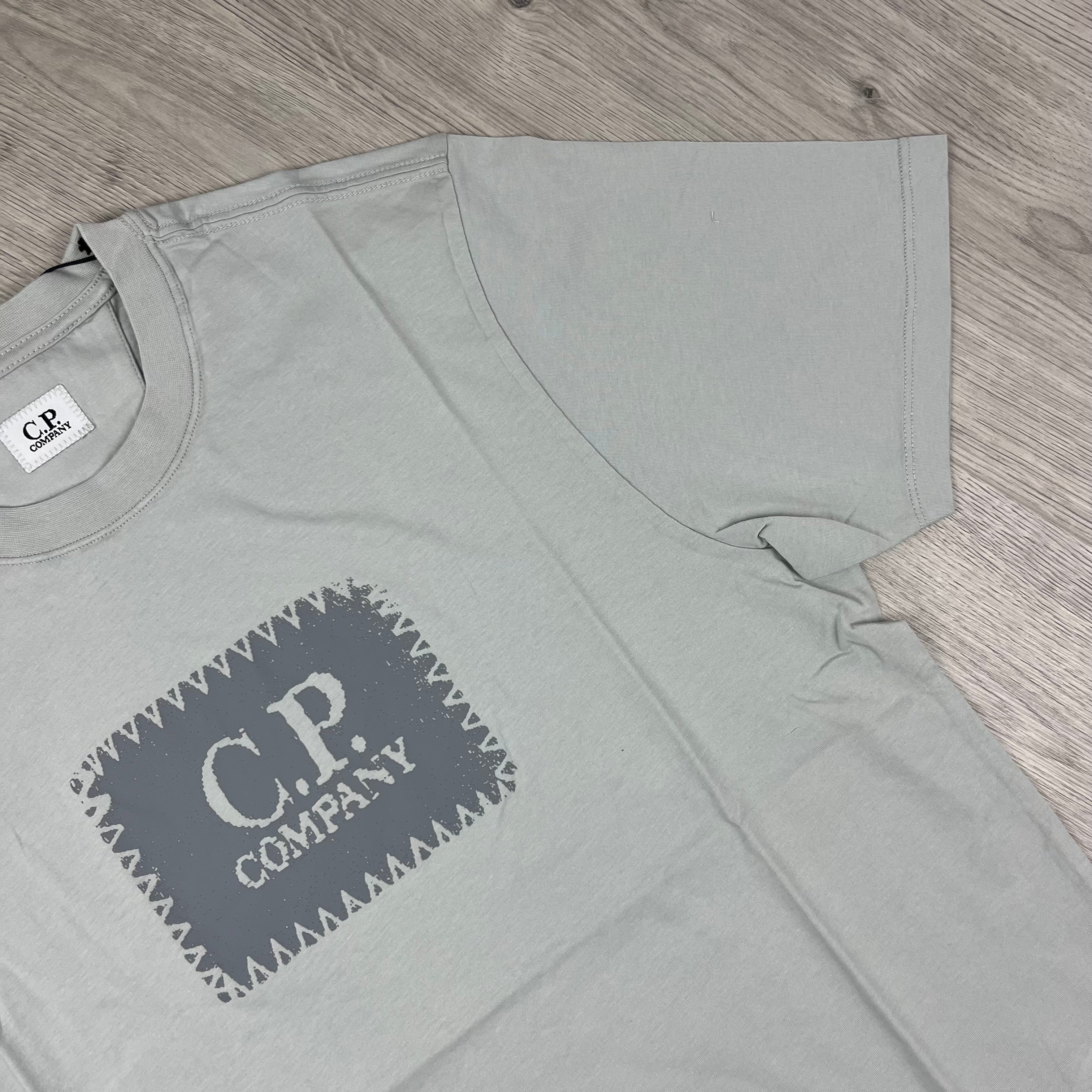 CP Company 30/1 Stamp Logo T-Shirt in Blue Fox. On sale at Open Attire.