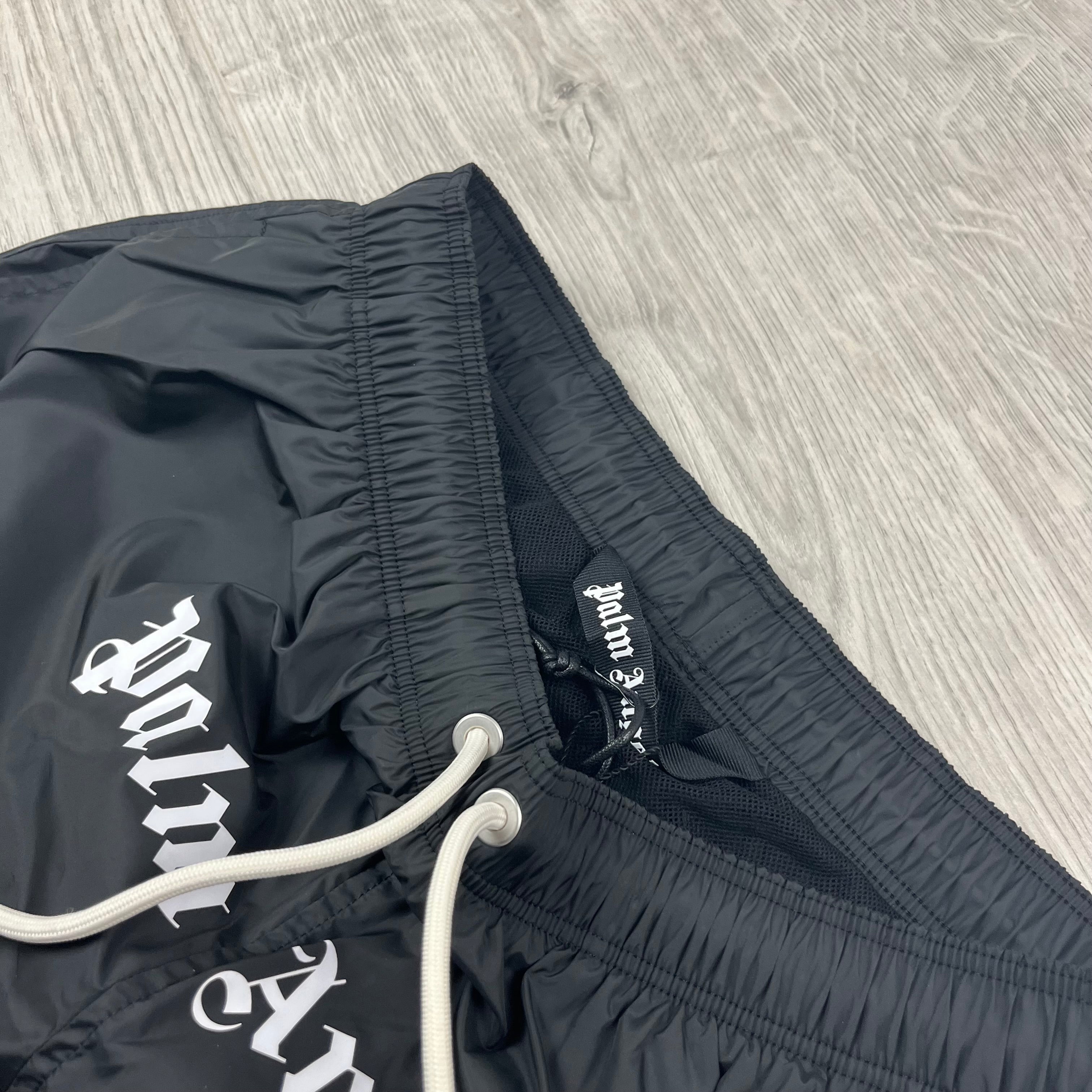 Palm Angels Gothic Logo Swim Shorts in Black. On sale at Open Attire.