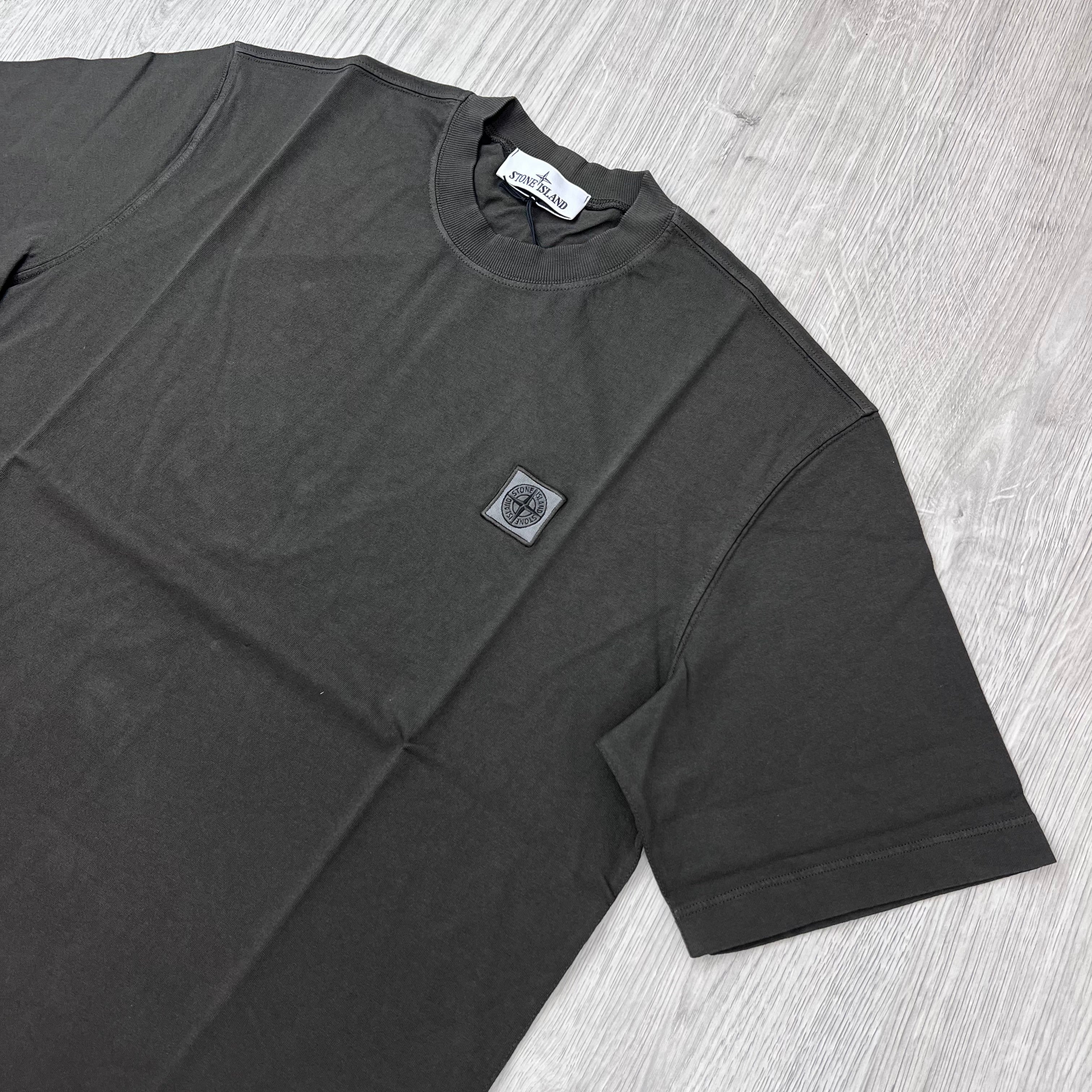 Angled view of a Stone Island Combed Organic Patch T-Shirt in Coal Grey. 