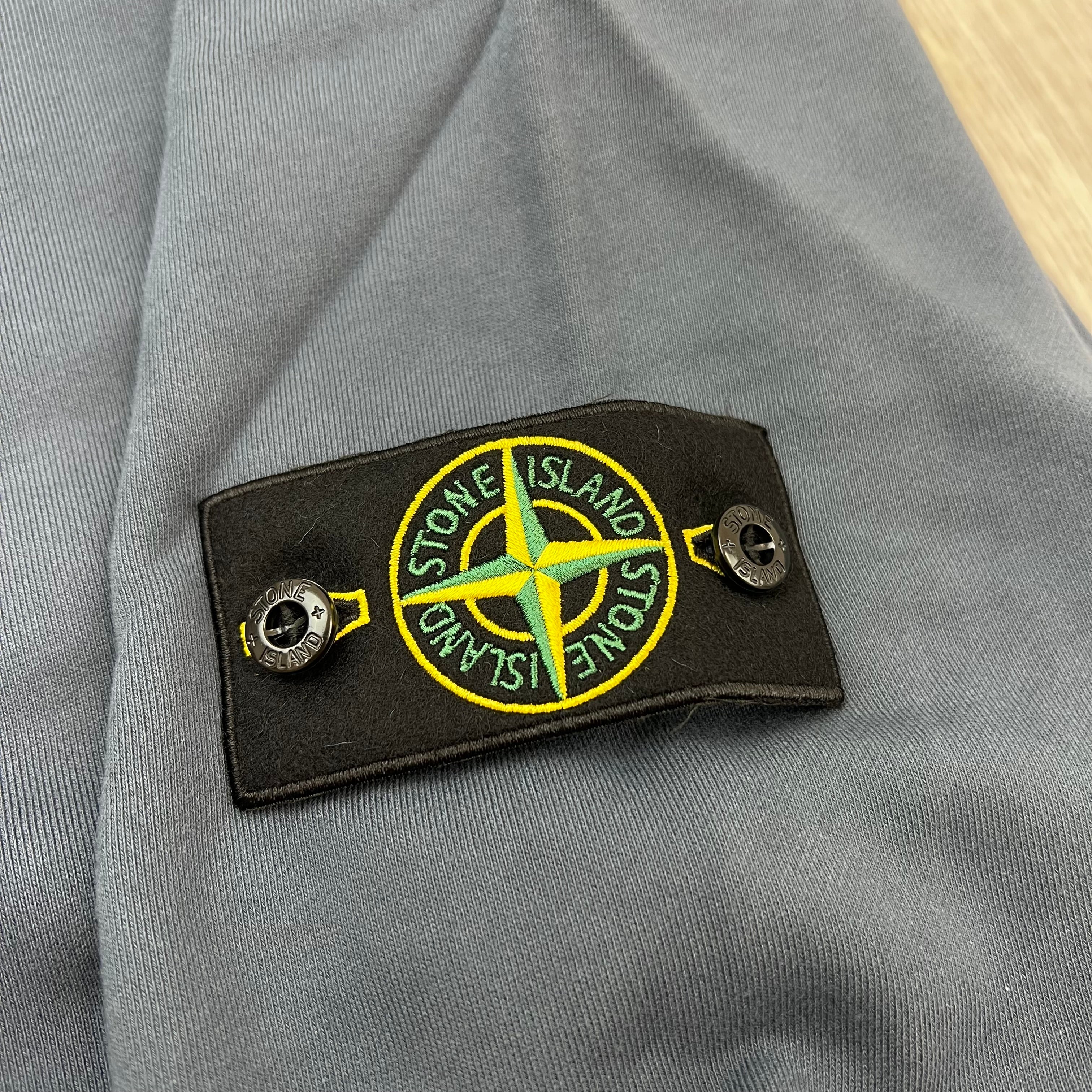 A close up view of the badge logo on a Stone Island Crewneck Sweatshirt in Slate Blue.