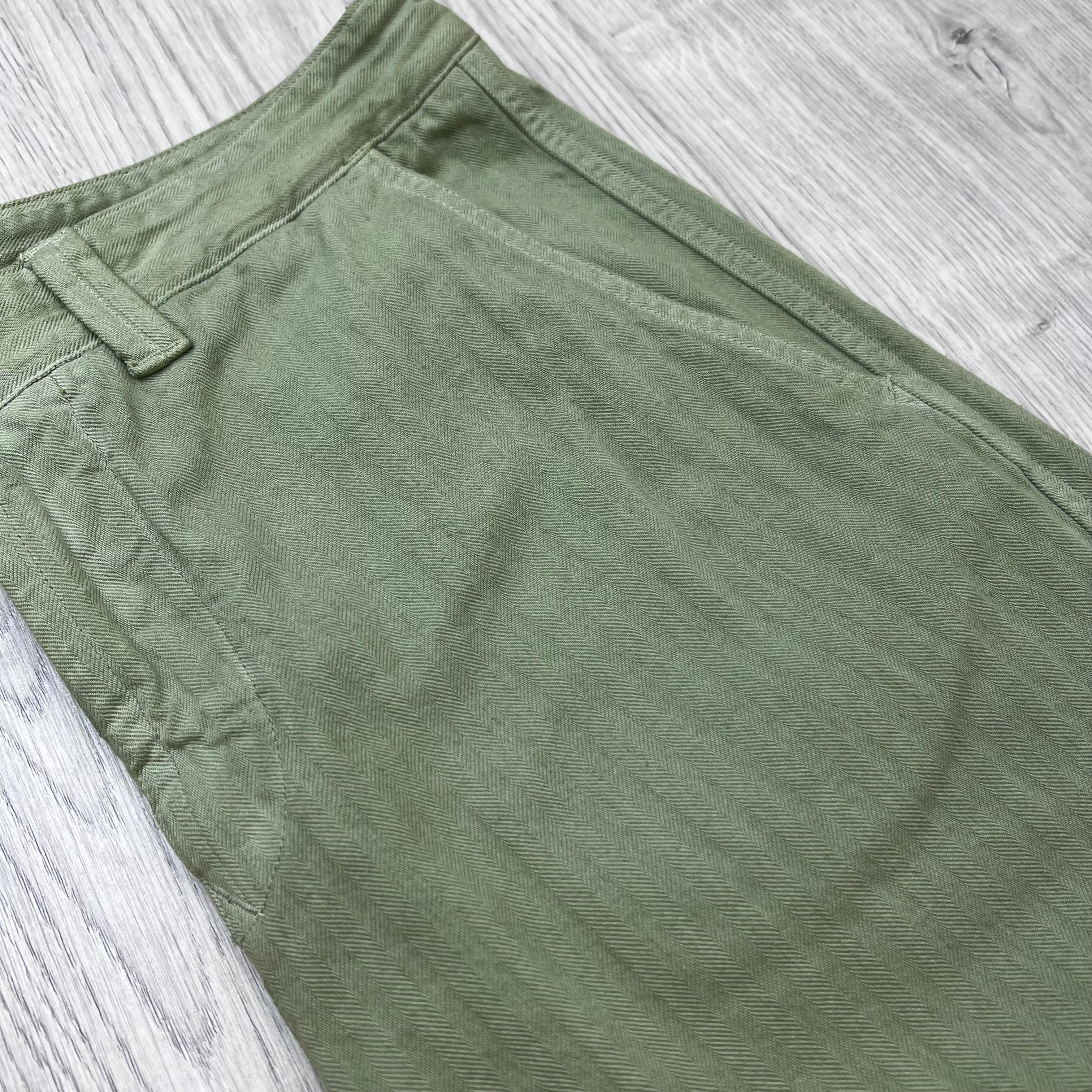 A close up view of the classic pattern on the Stone Island Cotton Herringbone Chino Trousers in Laurel Green.