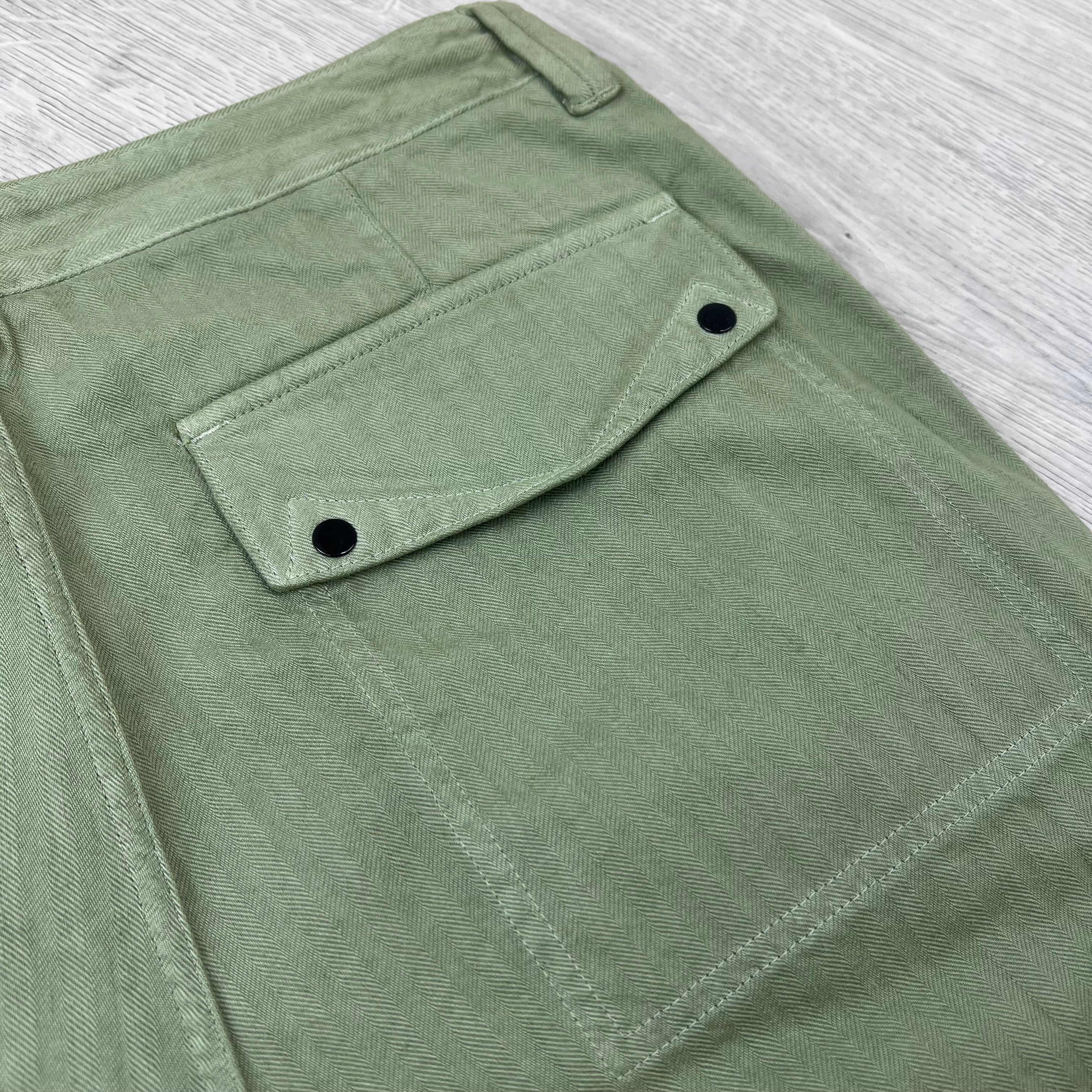 A close up view of back patch pocket on the Stone Island Cotton Herringbone Chino Trousers in Laurel Green.