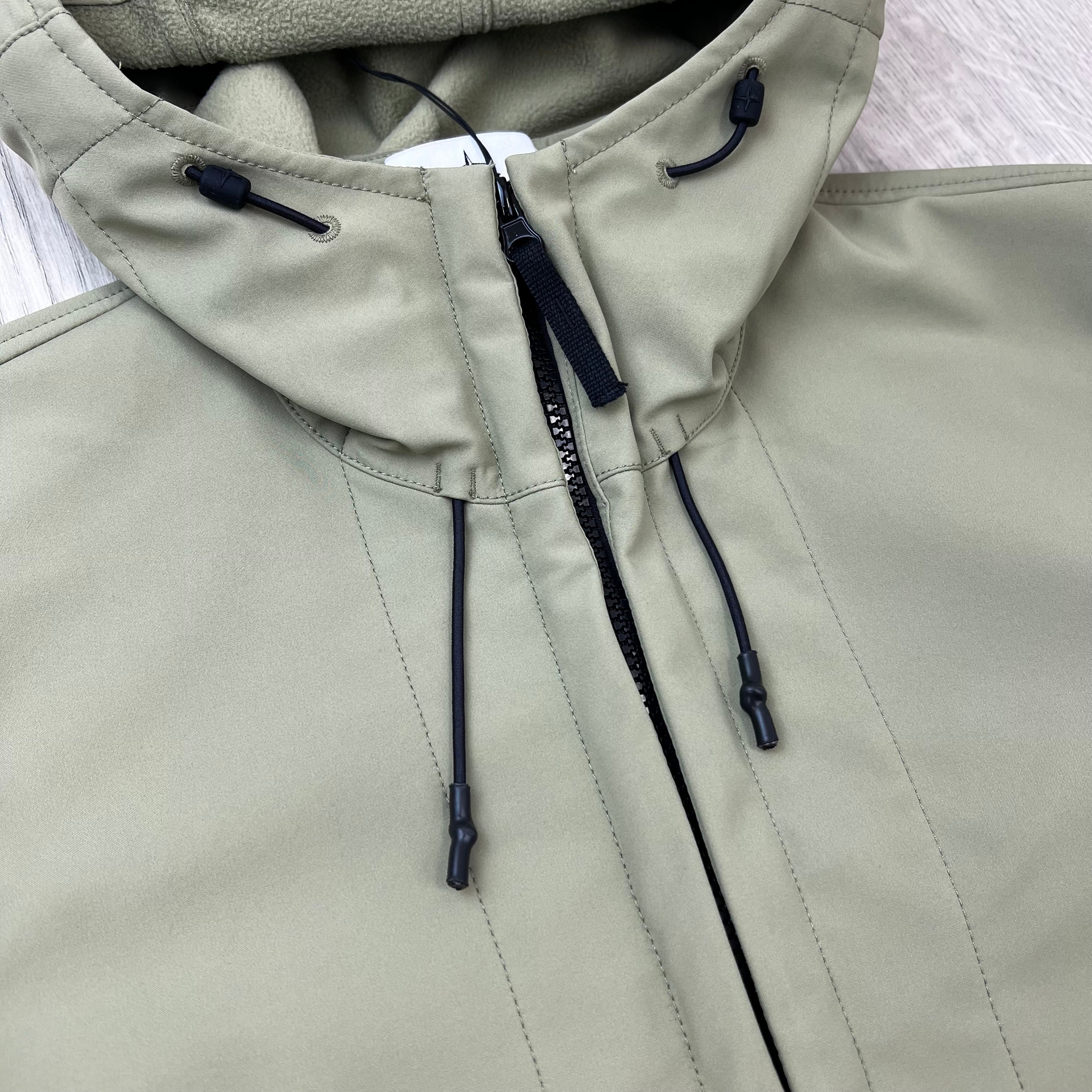 A close up view of the zip closure on a Stone Island Soft Shell-R_e.dye® Jacket in Laurel Green.