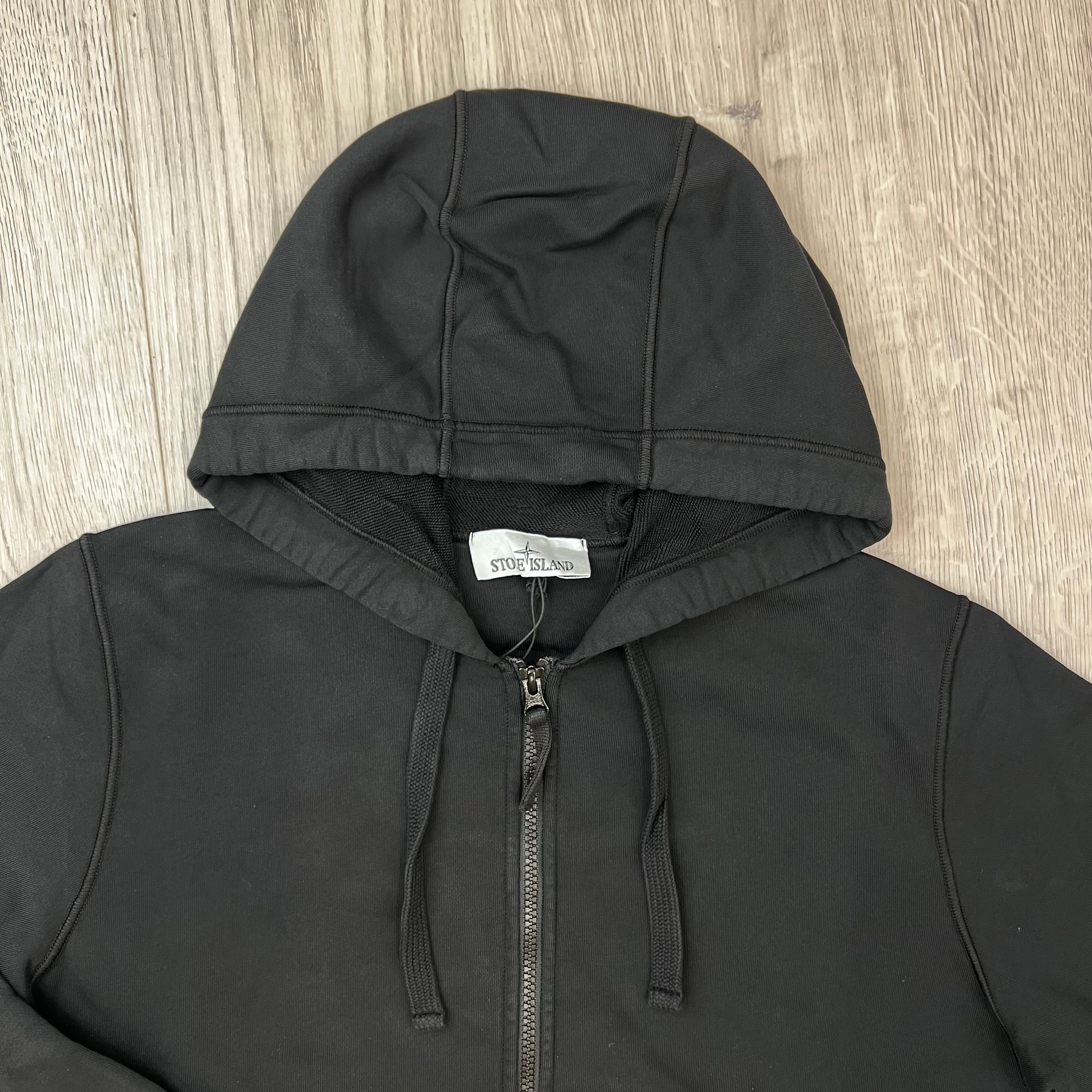 A close up view of the hood and drawstring on the Stone Island Zip Hoodie in Black. 