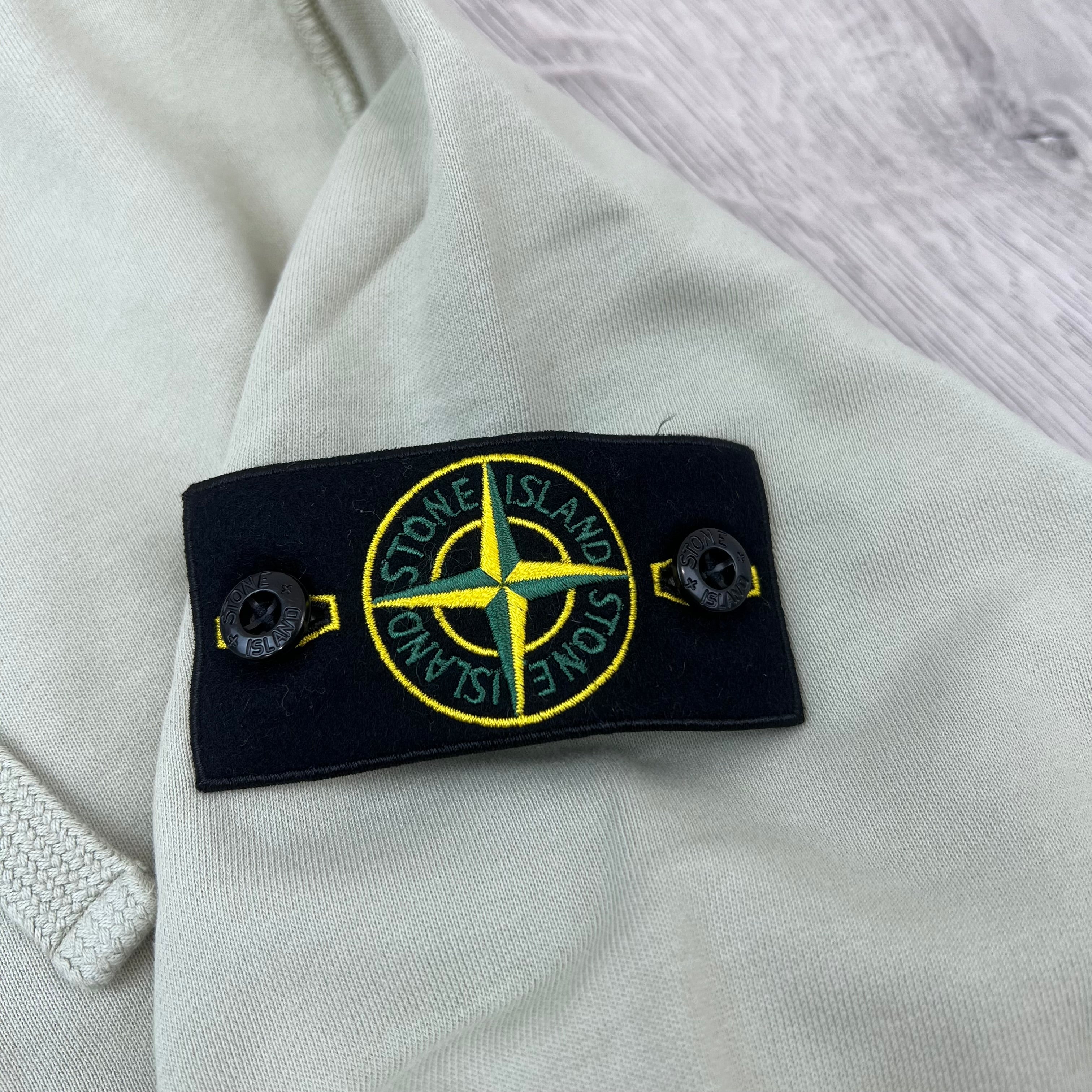 A close up view of the badge logo on the Stone Island Zip Hoodie in Sand. 